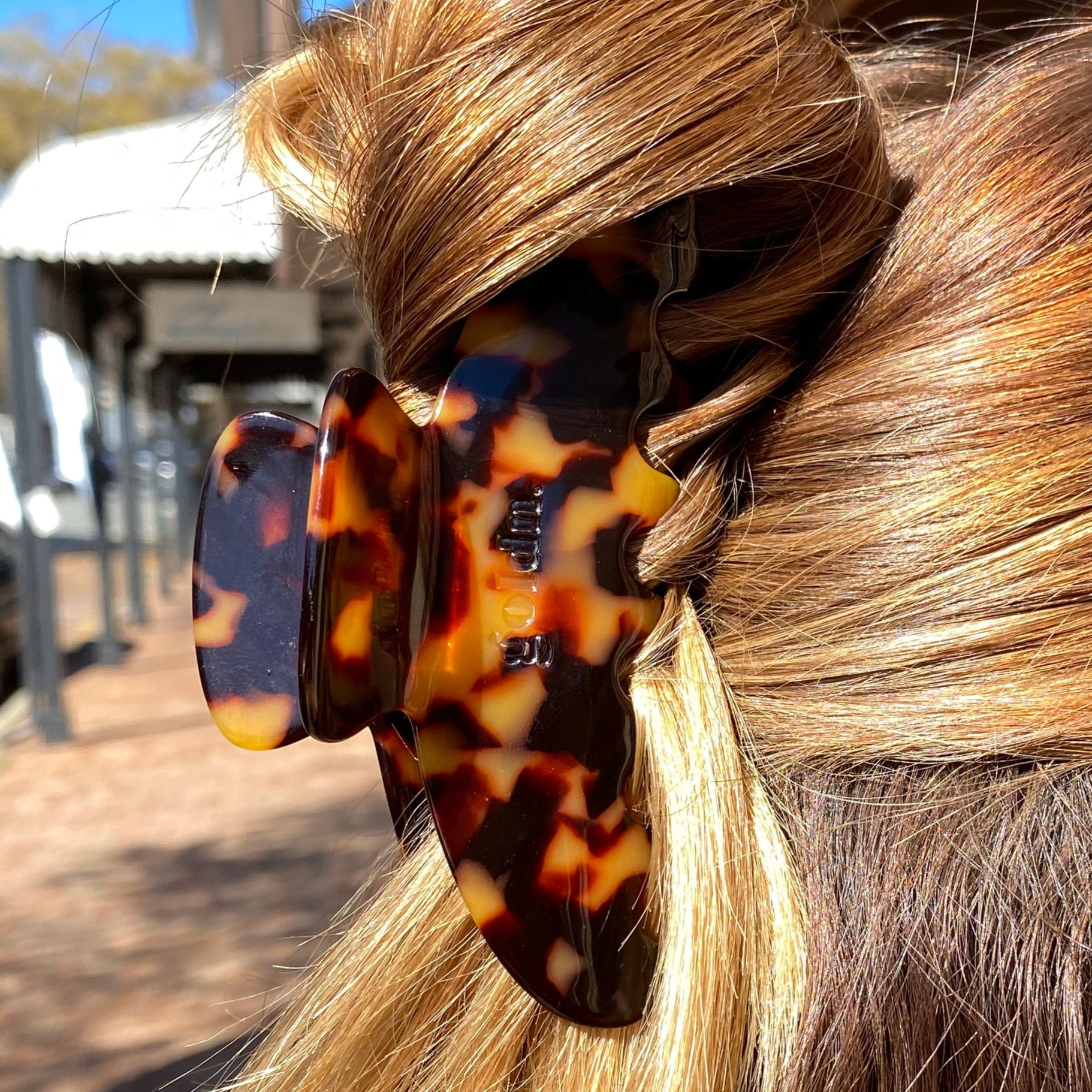 Close-up of a hair bun with a tortoiseshell clip against a blurred indoor background