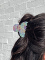 Multicolored hair tie on a bun against a textured gray background