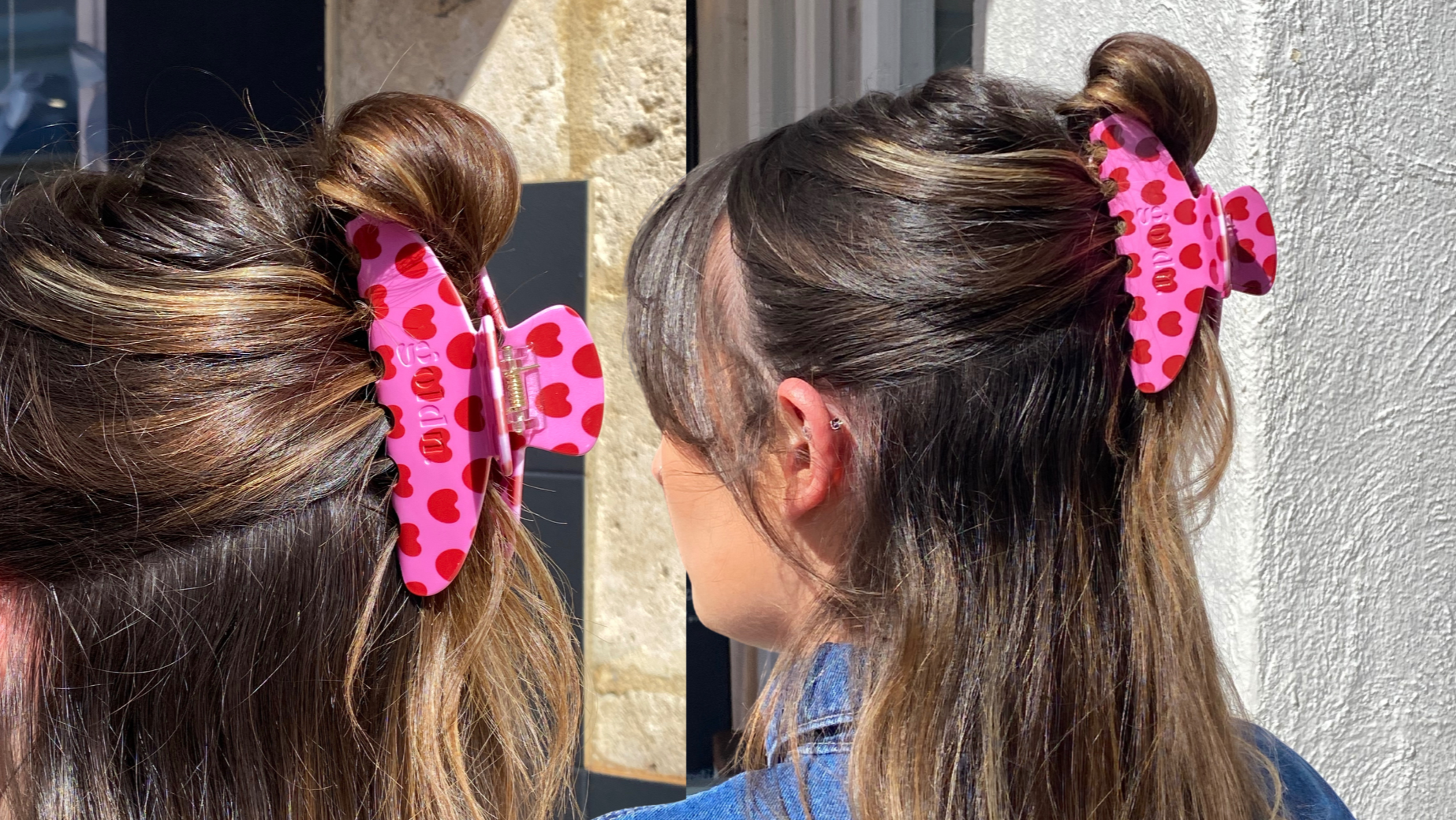 Two children with their hair styled in buns with pink hair accessories, standing against a neutral wall.