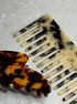 Two tortoiseshell combs on a gray surface large arch claw clip in tortoiseshell