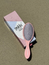 Load image into Gallery viewer, Goldn&#39; Wet/Dry HairBrush in pink with durable metal bristles, placed on its stylish packaging. Designed for effortless detangling on wet and dry hair.
