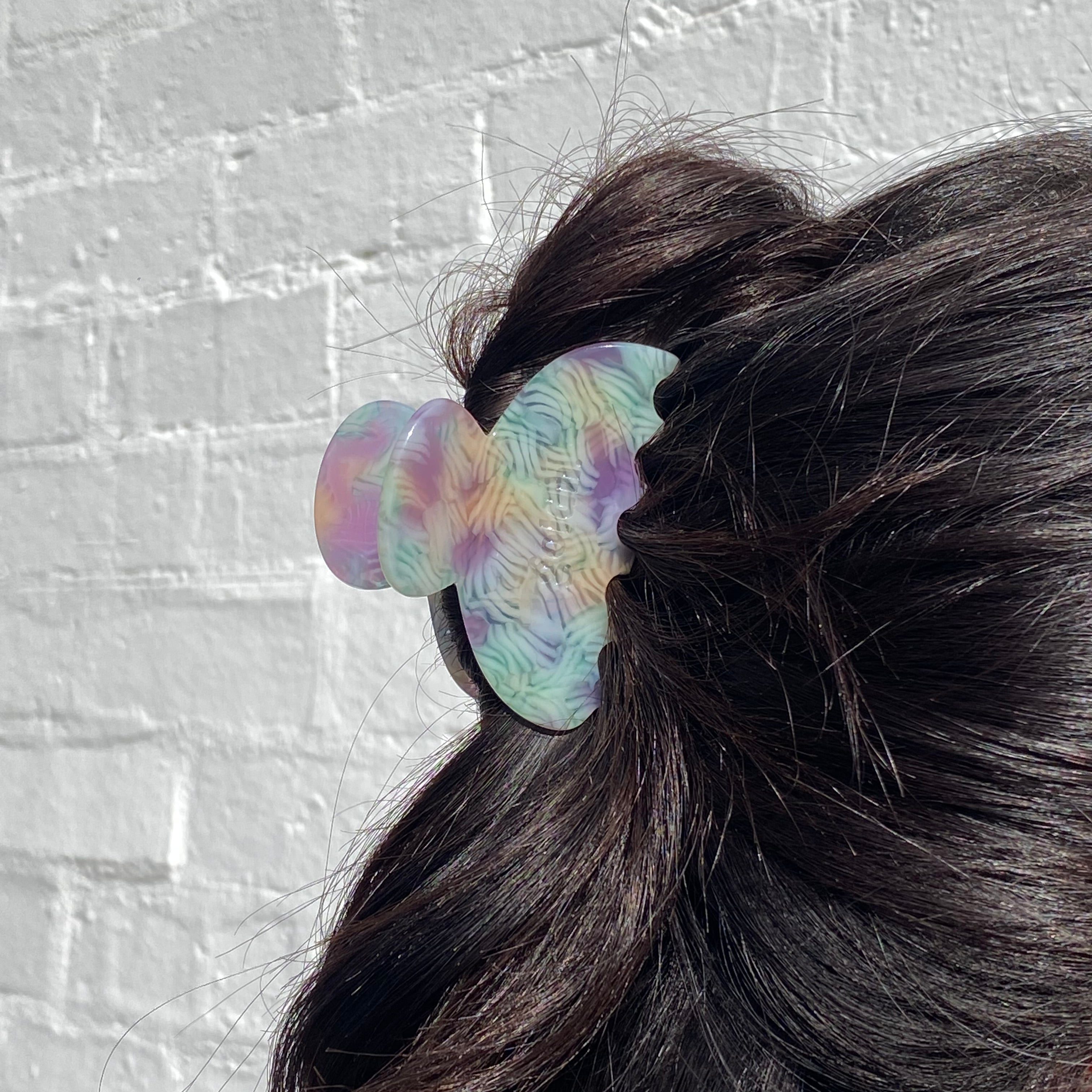Multicolored hair tie on a bun against a textured gray background