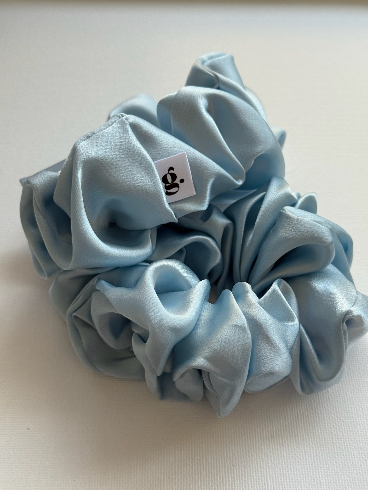 Light blue scrunchie with a small label on a light background