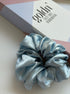 Light blue scrunchie with a box labeled 'goldin' in the background